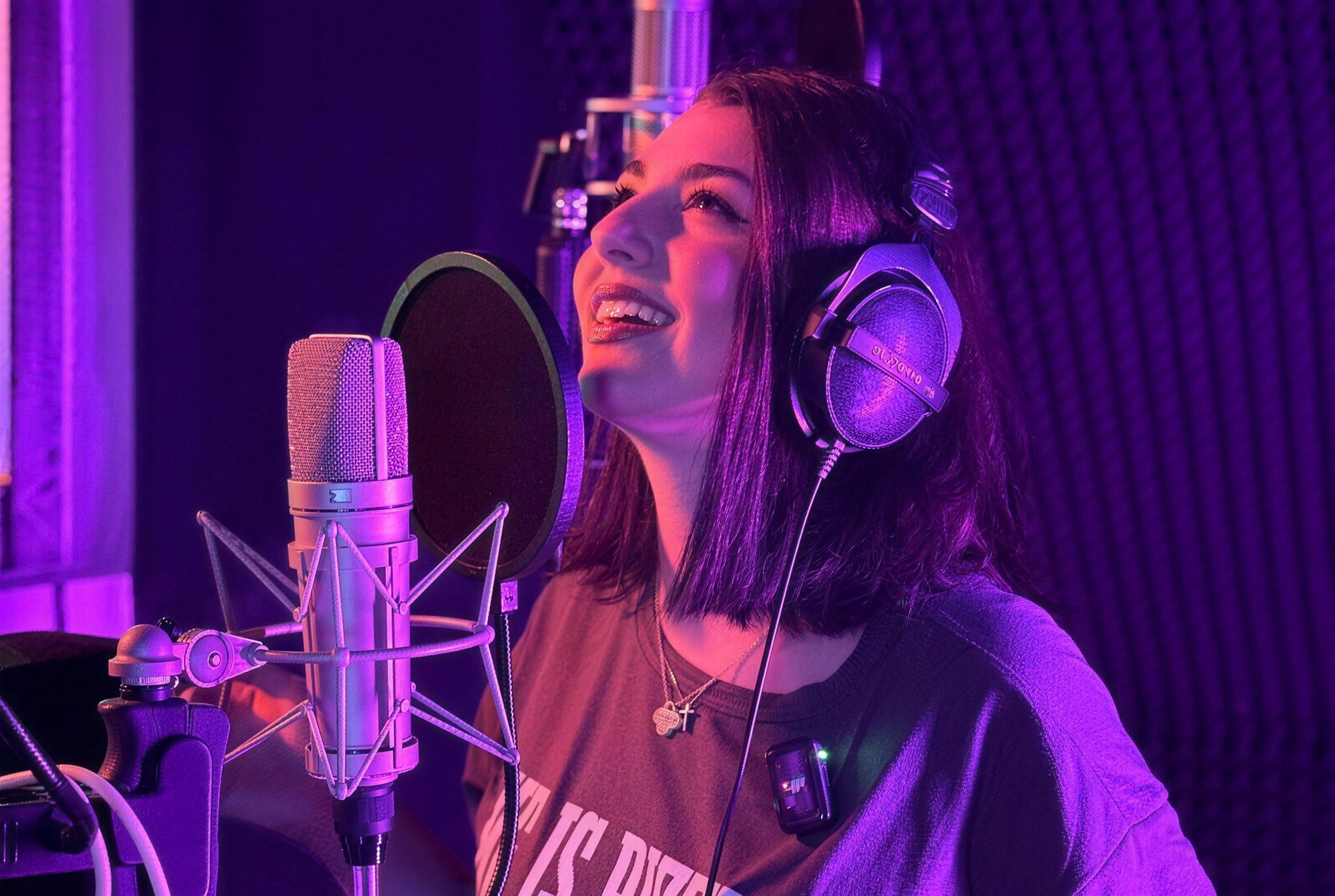 Sängerin lacht am Mikrofon im Studio